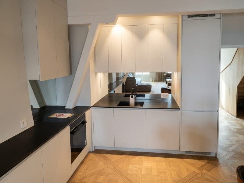 Cuisine sous combles — façades blanches et crédence miroir